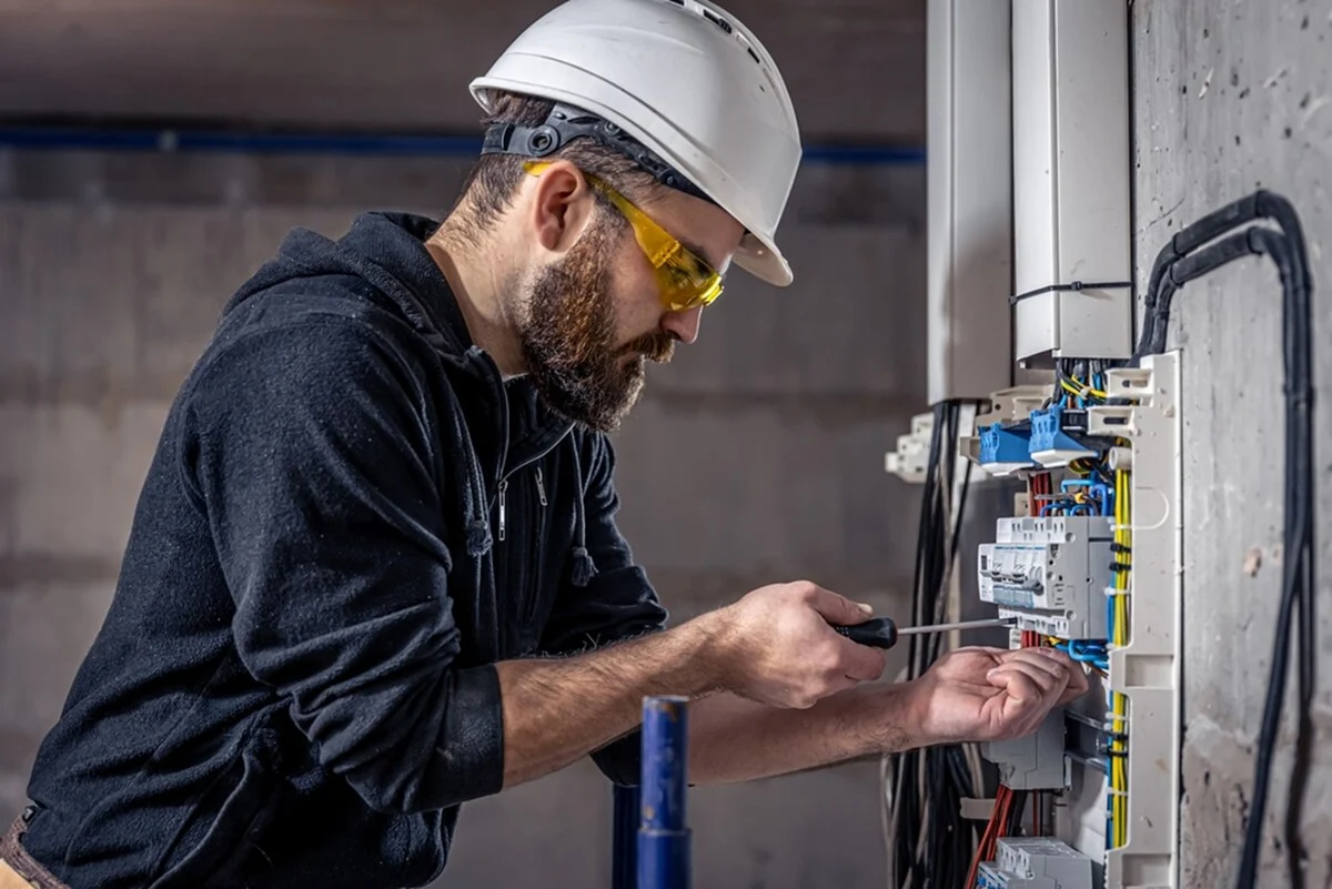 electrician montand un releu de tensiune