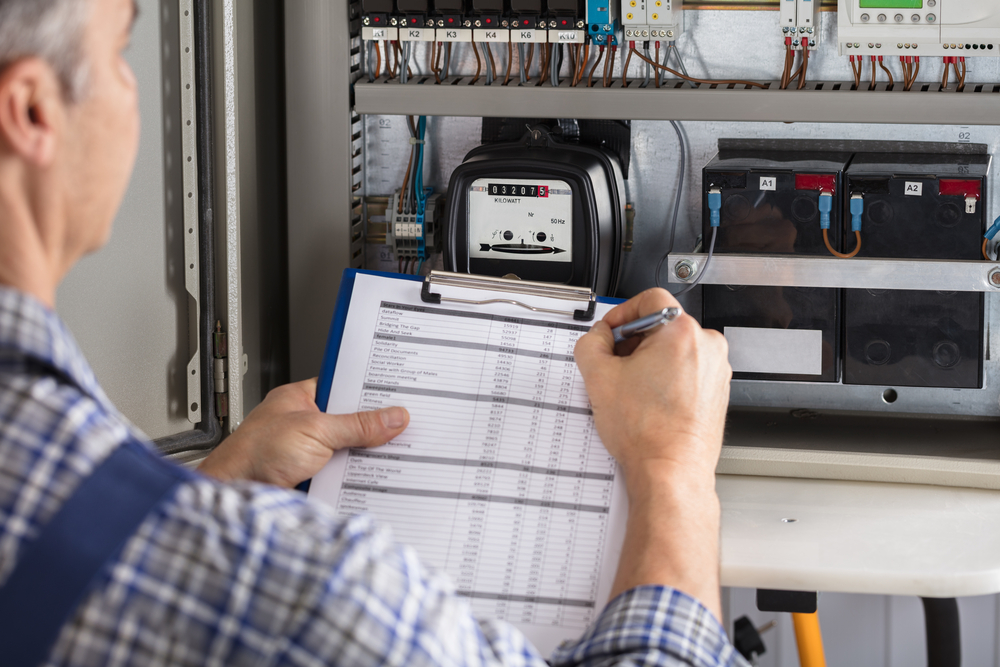 persoana care citeste indexul unui contor electric si noteaza valorile